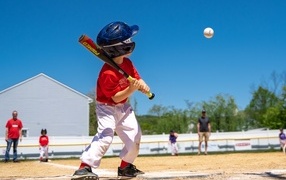 Маленький мальчик играет в бейсбол 