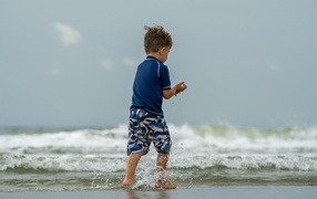 Little boy walking along the seashore