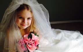 Маленькая девочка в костюме невесты с букетом
