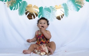 Little girl eating cake on white background