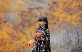 Little girl with a pumpkin in her hands