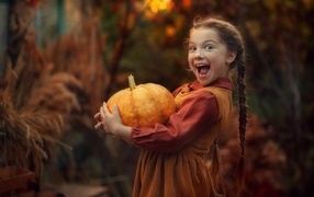 Little red-haired girl with pumpkin
