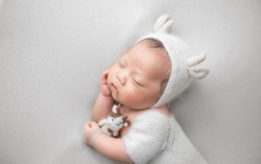 Little sleeping baby on a gray background