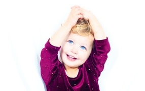 Little smiling blue-eyed girl on a white background