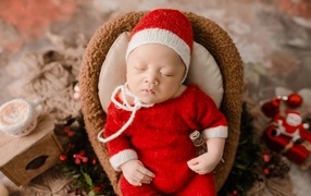 Новорожденный малыш в красном вязаном костюме
