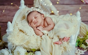 Новорожденная спящая девочка в белой кровати