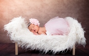 Sleeping newborn baby girl in fluffy skirt