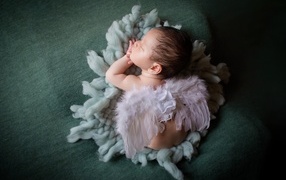 Спящий новорожденный малыш с крыльями ангела 
