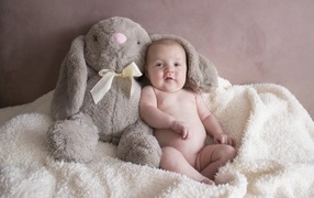 Smiling baby with a toy hare