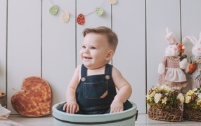 Smiling child sitting in a bucket