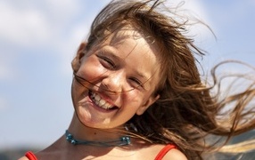 Smiling little girl standing in the wind