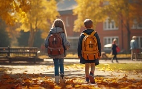 Двое детей школьников с рюкзаками на спине