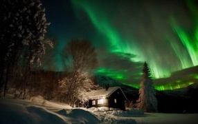 Beautiful green aurora over snow covered house