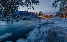 Покрытая льдом река с заснеженными берегами