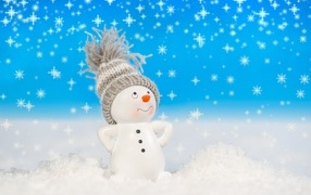 Toy snowman stands on white snow