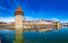 Башня и дома отражаются в воде, город Люцерн. Швейцария