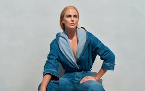 Актриса Шарлиз Терон в джинсовом костюме на сером фоне