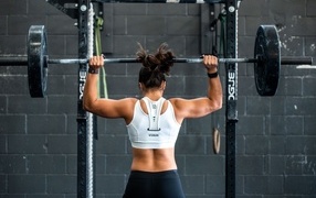 Girl athlete pumping a barbell