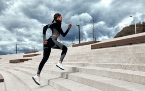 Девушка спортсменка бежит по лестнице