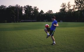 Мужчина футболист с мячом на поле