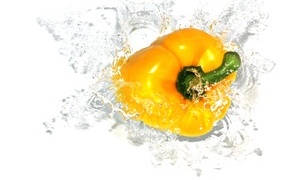 Yellow sweet pepper in water on white background