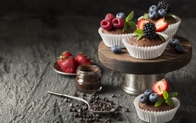 Кексы со свежими ягодами на столе с шоколадом