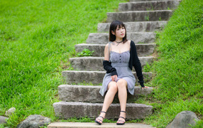 Beautiful young Asian girl sitting on the steps