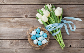 Bouquet of white tulips with a basket of Easter eggs