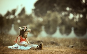 Asian girl sitting with a book on the ground