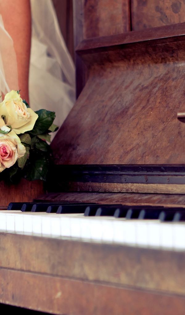 An old piano with a bouquet of roses
