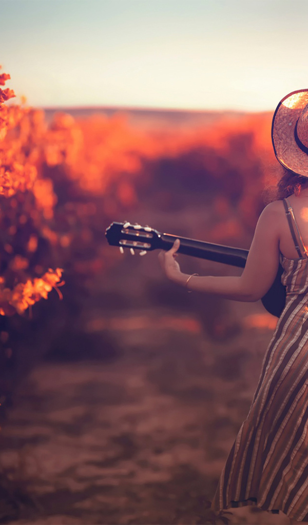 Девушка с гитарой в винограднике