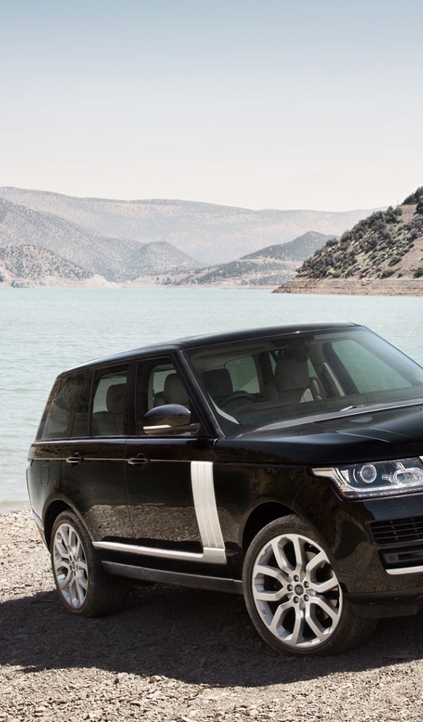 Черный Range Rover на берегу водоема