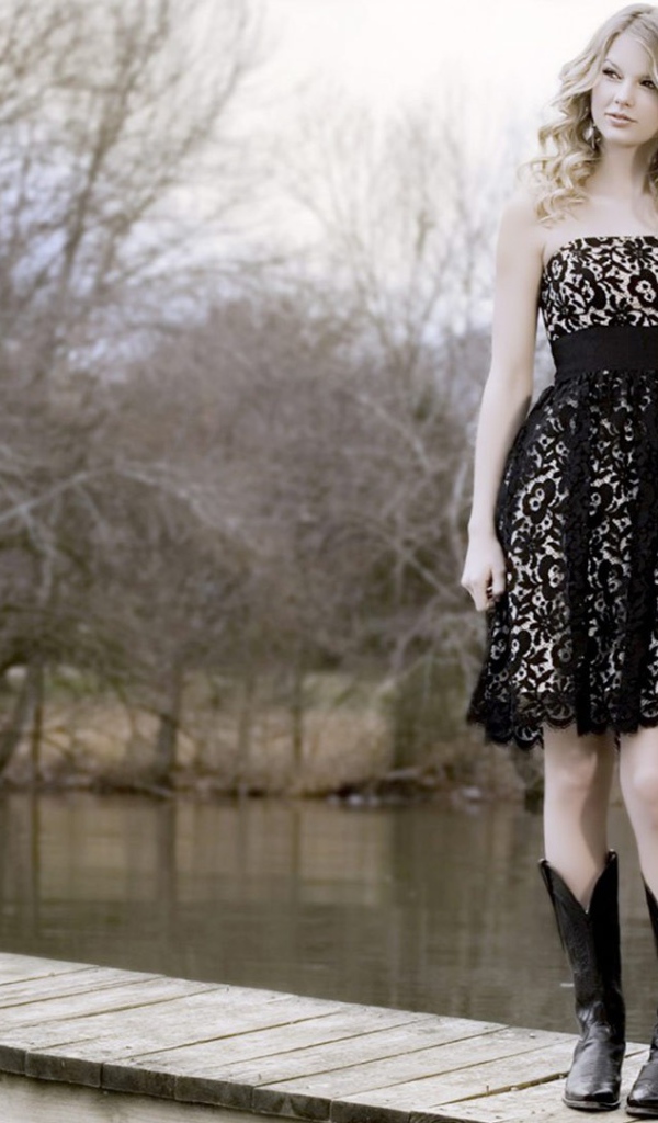 Девушка в черном платье и кожаных сапогах