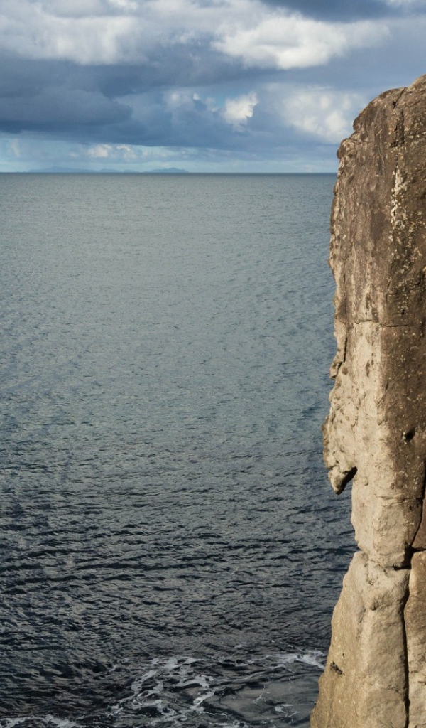 Мужчина скалолаз на скале над морем
