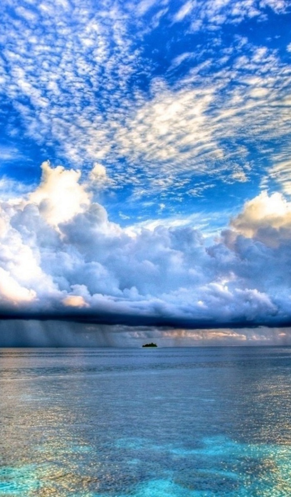 Разные облака над островком в океане