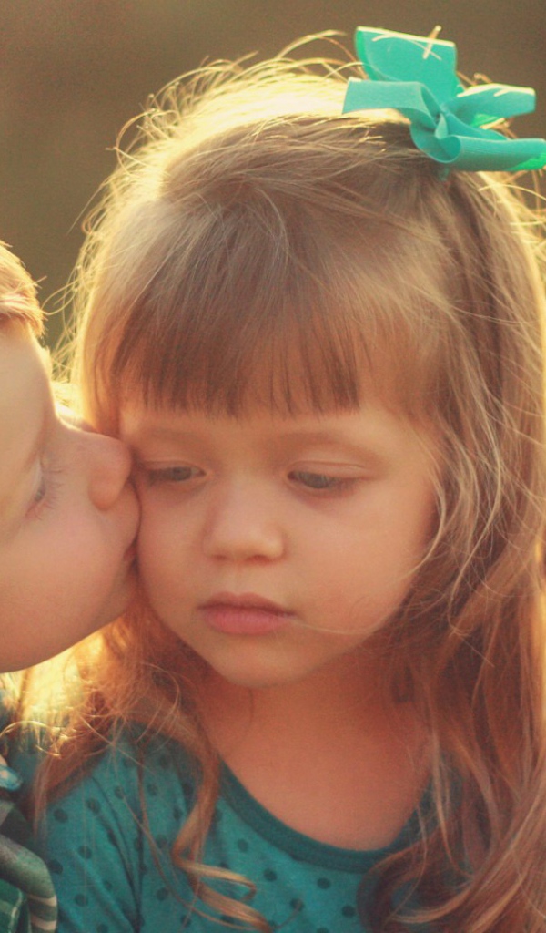 Мальчик целует сестренку в щеку