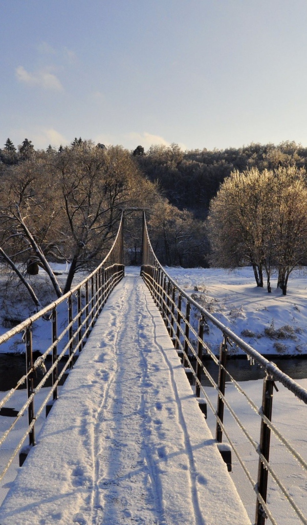 Следы на снегу на мосту через реку