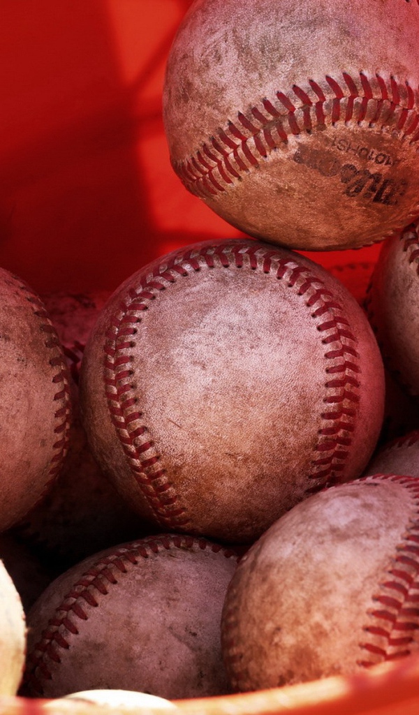 Красное ведро с мячами для бейсбола