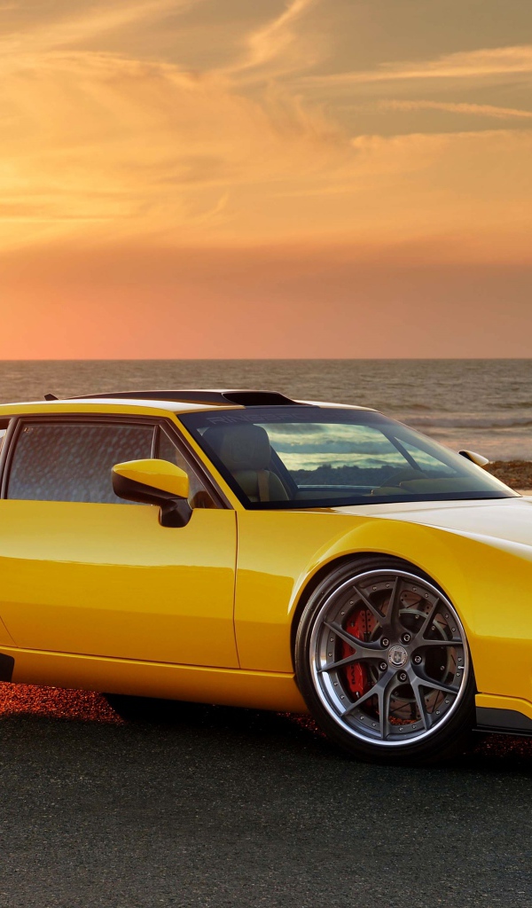 Желтый спортивный автомобиль De Tomaso Pantera на фоне заката