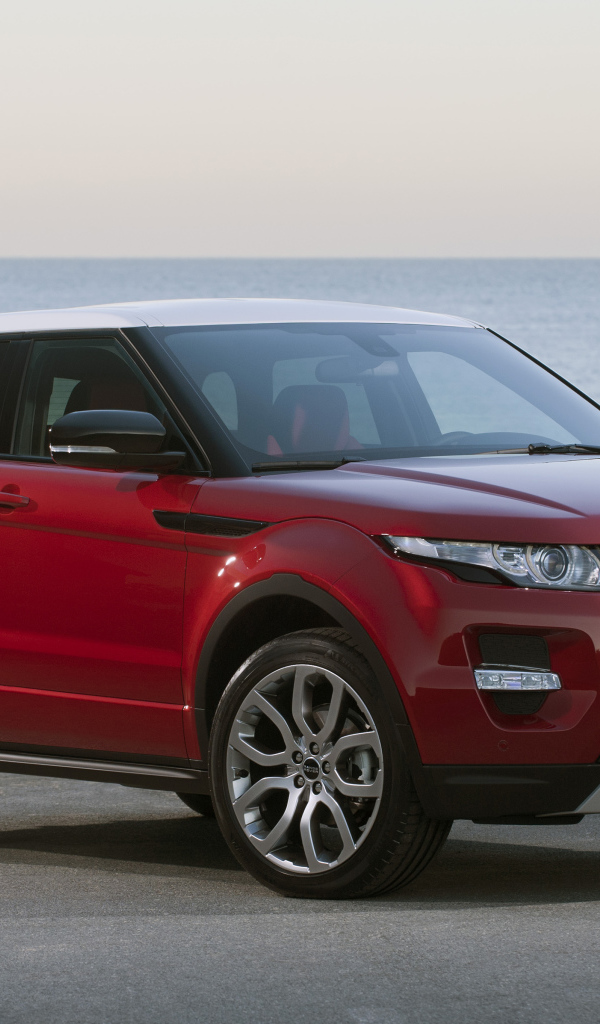 Красный автомобиль Land Rover Caractere на фоне океана