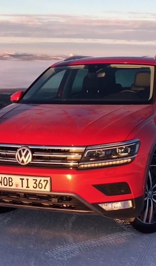 Красный Volkswagen Tiguan 2017 года на заснеженной трассе 