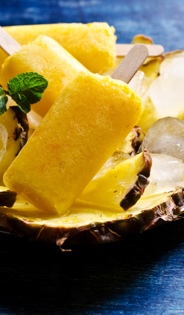 Ананасовое мороженое со льдом лежит на кусочках свежего ананаса