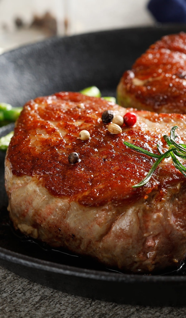 Two appetizing juicy pieces of meat with tomatoes and rosemary
