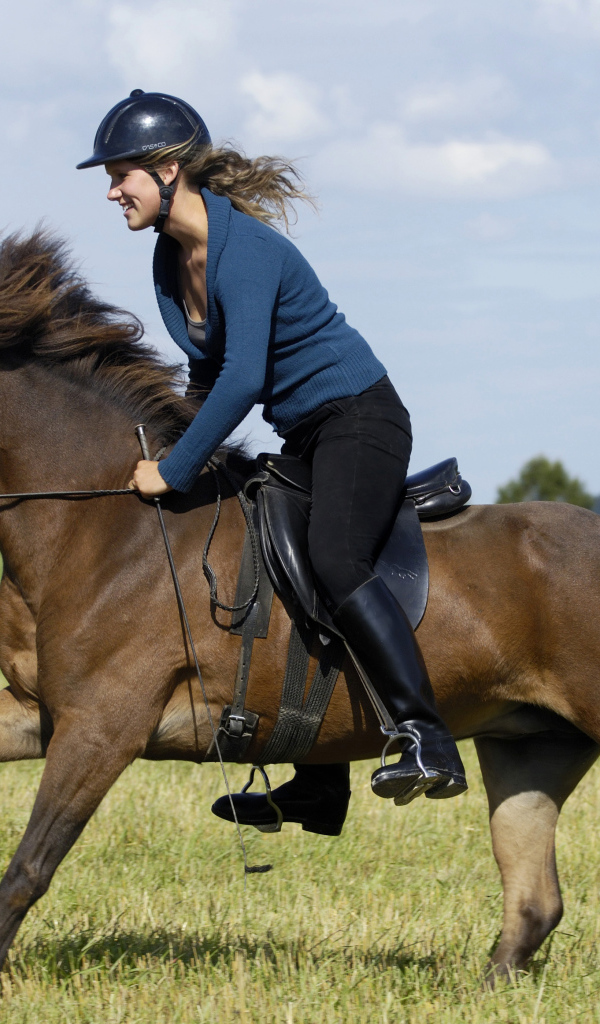 Молодая девушка в шлеме скачет на коричневой лошади