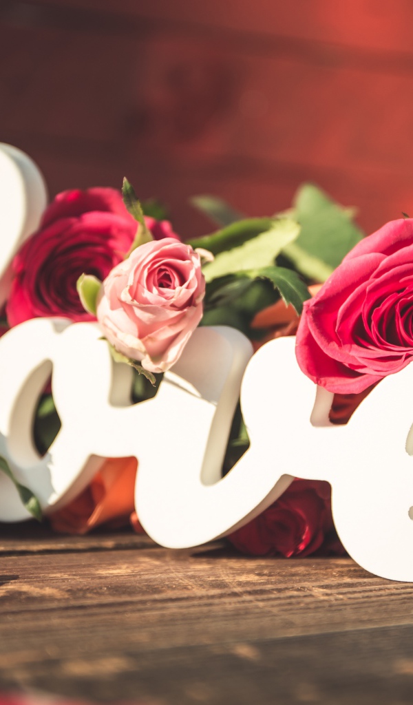 Белая надпись любовь с букетом роз