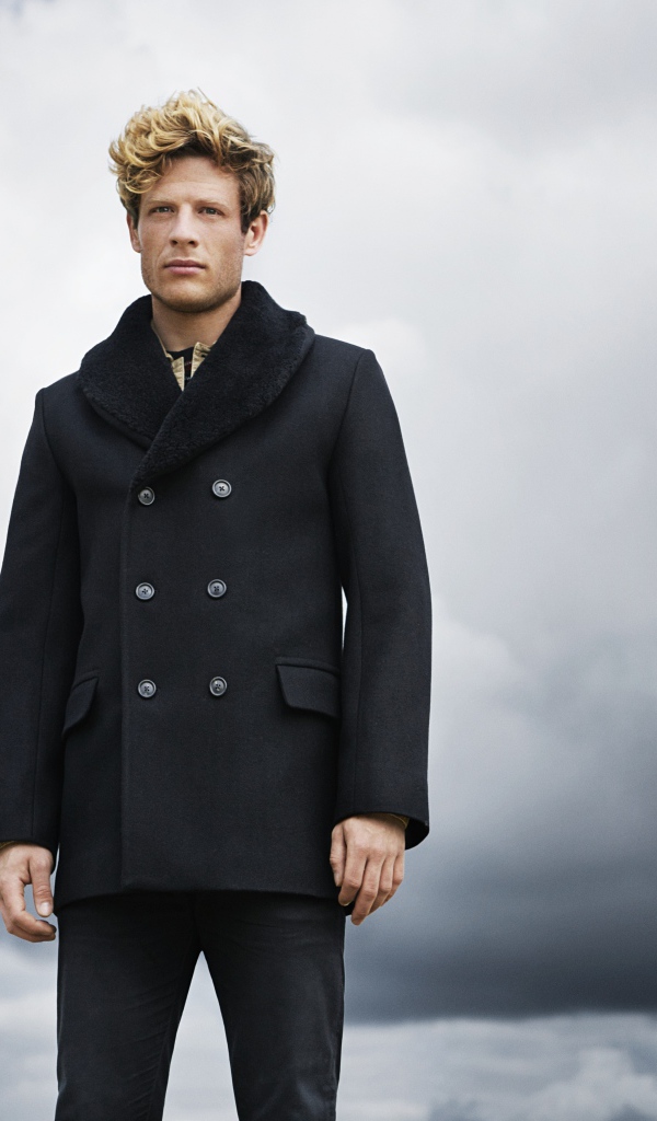 Актер Джеймс Нортон в черном пальто на фоне неба