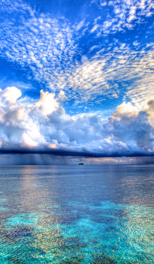 Красивые облака отражаются в голубой воде океана