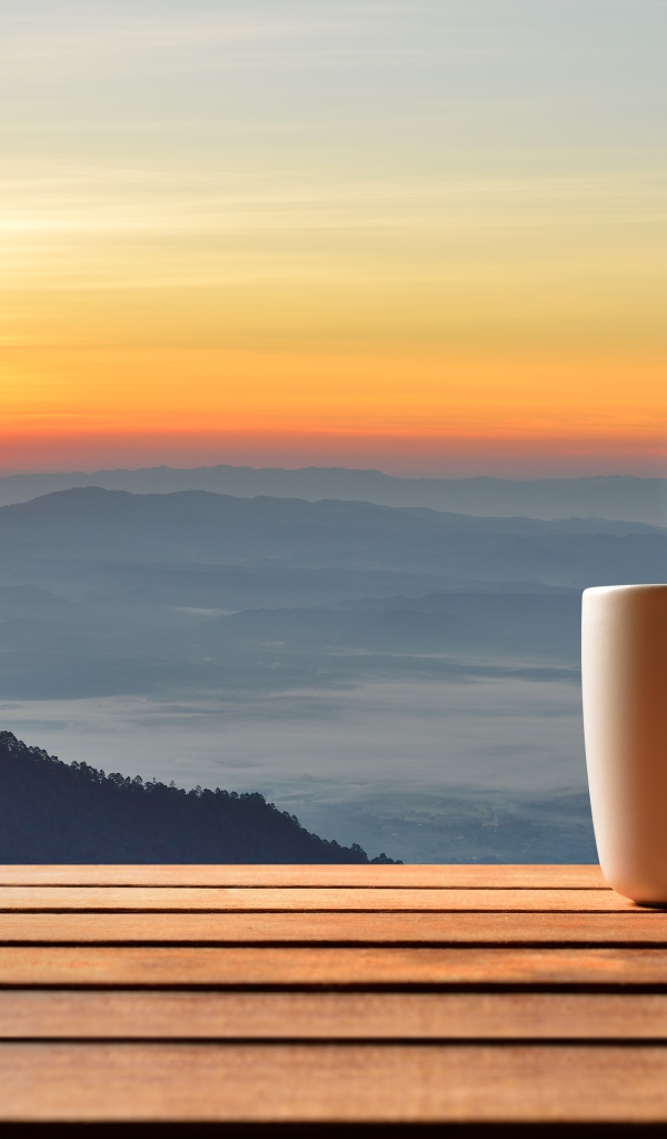 Чашка фоне на фоне горизонта с восходящим солнцем