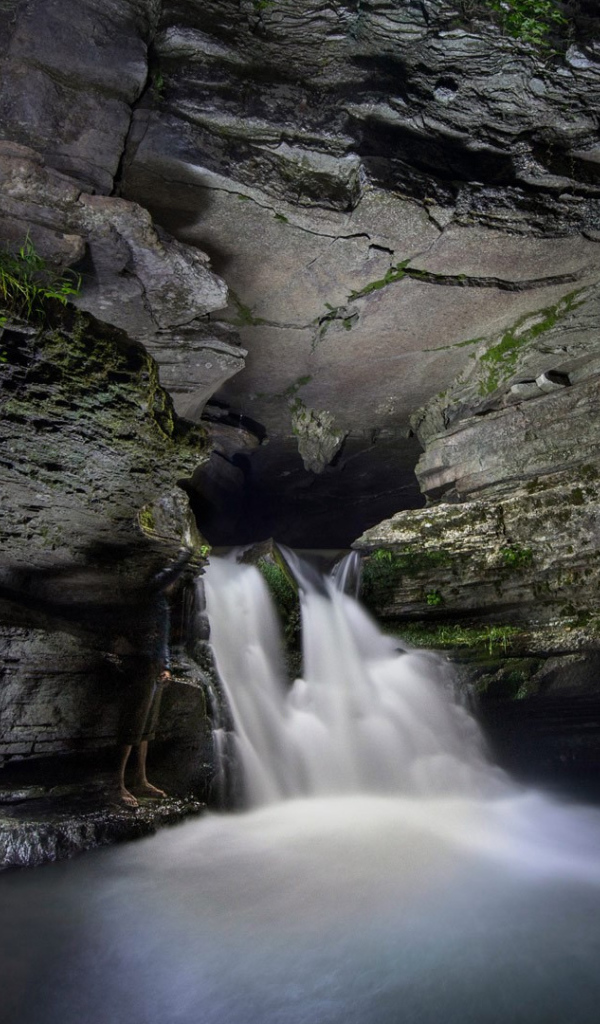 Быстрый водопад в каменной пещере 