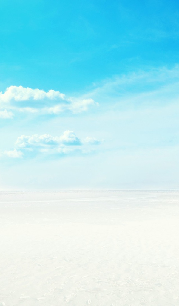 Шезлонг на белом песке на фоне голубого неба